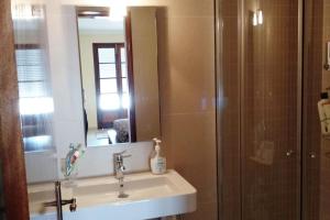 a bathroom with a sink and a shower with a mirror at AS CEGONHAS - ALOJAMENTo LOCAL in Olhão