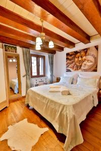 a bedroom with a large bed with a painting on the wall at Royal Suite Mia in Piran