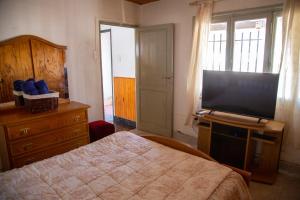 1 dormitorio con 1 cama y TV de pantalla plana en Casa San Rafael en San Rafael