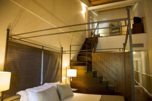a room with a bed and a spiral staircase at Hotel Nuevo Portil Golf in El Rompido +37 photos