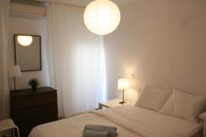 a bedroom with a white bed and a light fixture at Campo Grande Residence in Lisbon