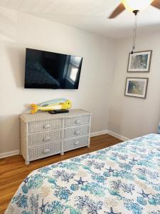 a bedroom with a bed and a tv on a wall at Ocean View & Easy Beach Access! in Surf City