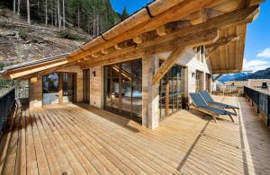 Casa con terraza de madera con techo en Alphotel Tyrol, en Racines