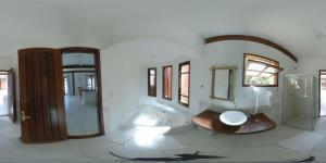 een badkamer met een bad, een wastafel en een spiegel bij Arraial Praia Hotel Pousada in Arraial d'Ajuda