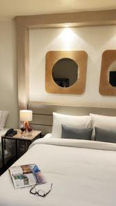 ノヴォ・アンブルゴにあるNovo Hamburgo Business Hotelのベッド2台と鏡が備わるホテルルームです。