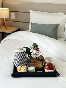 ein Tablett mit Essen auf dem Bett in der Unterkunft Novo Hamburgo Business Hotel in Novo Hamburgo