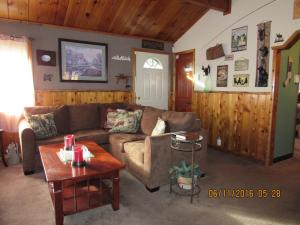 ein Wohnzimmer mit einem Sofa und einem Tisch in der Unterkunft Owl Pine Ranch in Big Bear City