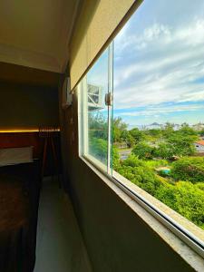 ventana en una habitación con vistas a un parque en Coberturas ou apartamentos 1min da praia do recreio com Vista Mar, en Río de Janeiro