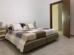 um quarto com uma cama grande com almofadas em oasi new appartment em Fasano
