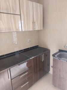 a kitchen with wooden cabinets and a sink at Quiet and comfortable place in Madinaty new cairo in Madinaty
