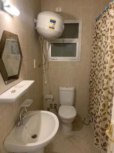 uma casa de banho com um lavatório, um WC e uma janela. em Quiet and comfortable place in Madinaty new cairo em Madinaty