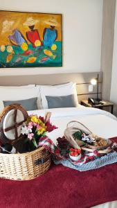 ein Bett mit einem Korb mit Essen und Blumen darauf in der Unterkunft Novo Hamburgo Business Hotel in Novo Hamburgo