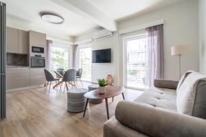 a living room with a couch and a table at Sea View Stylish Penthouse in Varkiza in Vari