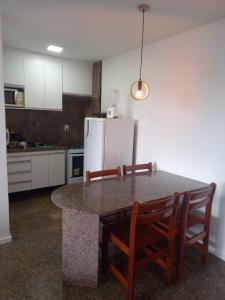 a kitchen with a table with chairs and a refrigerator at Hotel Flat Atlântico in Fortaleza