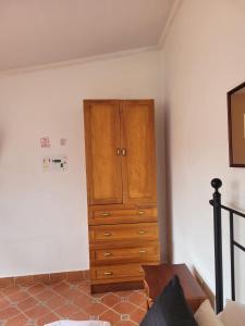 a bedroom with a dresser and a wooden cabinet at Casa Macondo Bed & Breakfast in Cuenca