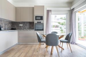 a kitchen with a dining room table and chairs at Sea View Stylish Penthouse in Varkiza in Vari