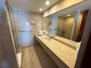 ein Badezimmer mit Waschbecken und großem Spiegel in der Unterkunft Hotel Quijote Inn in Mazatlán + 44 Fotos