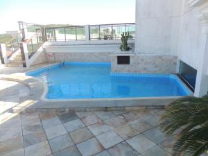 a swimming pool in a building with a balcony at Loft Com Vista Para O Mar in Arraial do Cabo