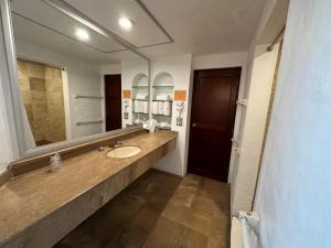 a bathroom with a sink and a large mirror at Hotel Quijote Inn in Mazatlán