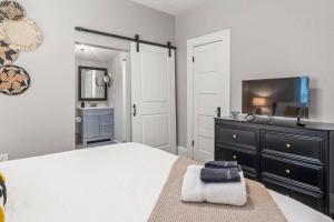 een slaapkamer met een bed en een flatscreen-tv bij BeeKeeper's Inn - Beautifully Renovated 1929 Bungalow with 2 Bedrooms on Brick Street near Tampa's Attractions in Tampa