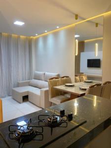 uma cozinha e sala de estar com uma placa de fogão em Apartamento Sofisticado em frente ao Shopping Caruaru em Caruaru