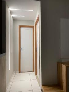 korytarzem z białymi drzwiami w pokoju w obiekcie Apartamento Sofisticado em frente ao Shopping Caruaru w mieście Caruaru
