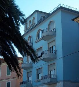 un edificio blanco con balcones y una palmera en Casa Bello, en Portovenere
