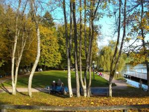 zwei Menschen sitzen auf einer Bank in einem Park in der Unterkunft Tannhäuser Ferienwohnung in Bad Dürrheim