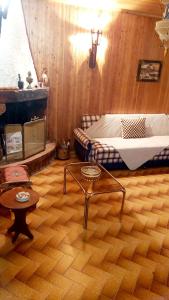 a bedroom with a bed and a table in a room at The log house in the village in Pramanta