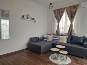 ein Wohnzimmer mit einem blauen Sofa und 2 Tischen in der Unterkunft Apartmani Meri in Privlaka