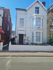 Ein weißes Haus an der Seite einer Straße in der Unterkunft Lawnswood Apartments in Blackpool