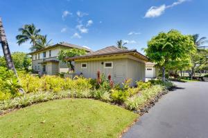 a house with a garden in front of a driveway at Luxe Maunalani Resort Condo with Pool and Beach Access in Waikoloa