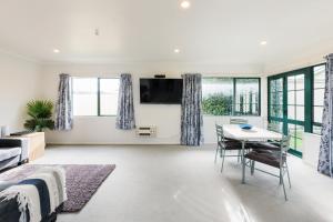 een woonkamer met een bed en een tafel bij Camelot Motor Lodge and Conference Centre in Palmerston North