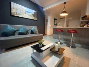 a living room with a couch and a red stool at Apto nuevo en Girardot, piscina, BBQ, terraza. in Girardot