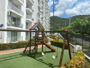 un parque infantil con columpio y cometa en Apto nuevo en Girardot, piscina, BBQ, terraza., en Girardot