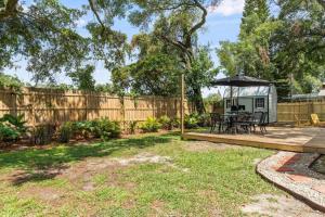 een achtertuin met een terras en een prieel bij BeeKeeper's Inn - Beautifully Renovated 1929 Bungalow with 2 Bedrooms on Brick Street near Tampa's Attractions in Tampa