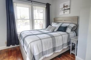 a bedroom with a bed with a striped blanket and a window at Bandera Bungalow - River, Downtown, Peaceful fenced corner lot! King bed! in Bandera