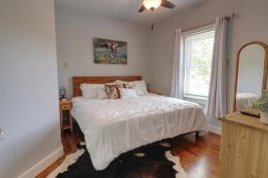 a bedroom with a bed and a mirror and a window at Bandera Bungalow - River, Downtown, Peaceful fenced corner lot! King bed! in Bandera