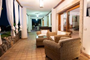a living room with wicker chairs and a table at Luxury Taorum villa with spectacular sea views in Taormina in Taormina
