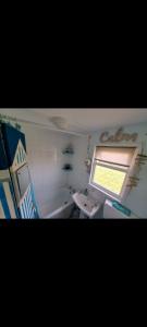 een badkamer met een bad, een wastafel en een raam bij California beachhut chalet in Great Yarmouth