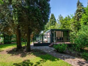 una casita verde en un parque con árboles en Boszicht, en Heeswijk-Dinther
