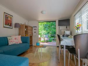 sala de estar con sofá azul y mesa en Boszicht, en Heeswijk-Dinther