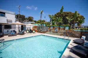a swimming pool with chairs and a house at Art Hotel Laguna Beach in Laguna Beach