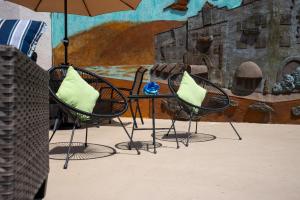 2 chaises et une table avec un parasol dans l'établissement Art Hotel Laguna Beach, à Laguna Beach