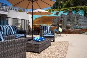 a patio with two chairs and an umbrella at Art Hotel Laguna Beach in Laguna Beach