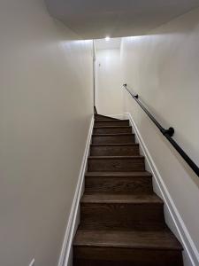 una scala in una camera con pareti bianche e pavimenti in legno di Rivera Properties a Washington