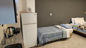 a bedroom with a refrigerator next to a bed at SOCRA Centro in Asunción
