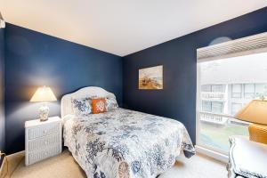 een blauwe slaapkamer met een bed en een raam bij Sea Colony --- 3201 Round Robin in Bethany Beach