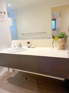 W łazience znajduje się umywalka i lustro. w obiekcie Southern Ocean Villa 9 w mieście Port Campbell