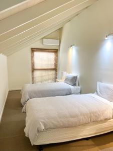 sypialnia z 2 łóżkami i oknem w obiekcie Southern Ocean Villa 9 w mieście Port Campbell